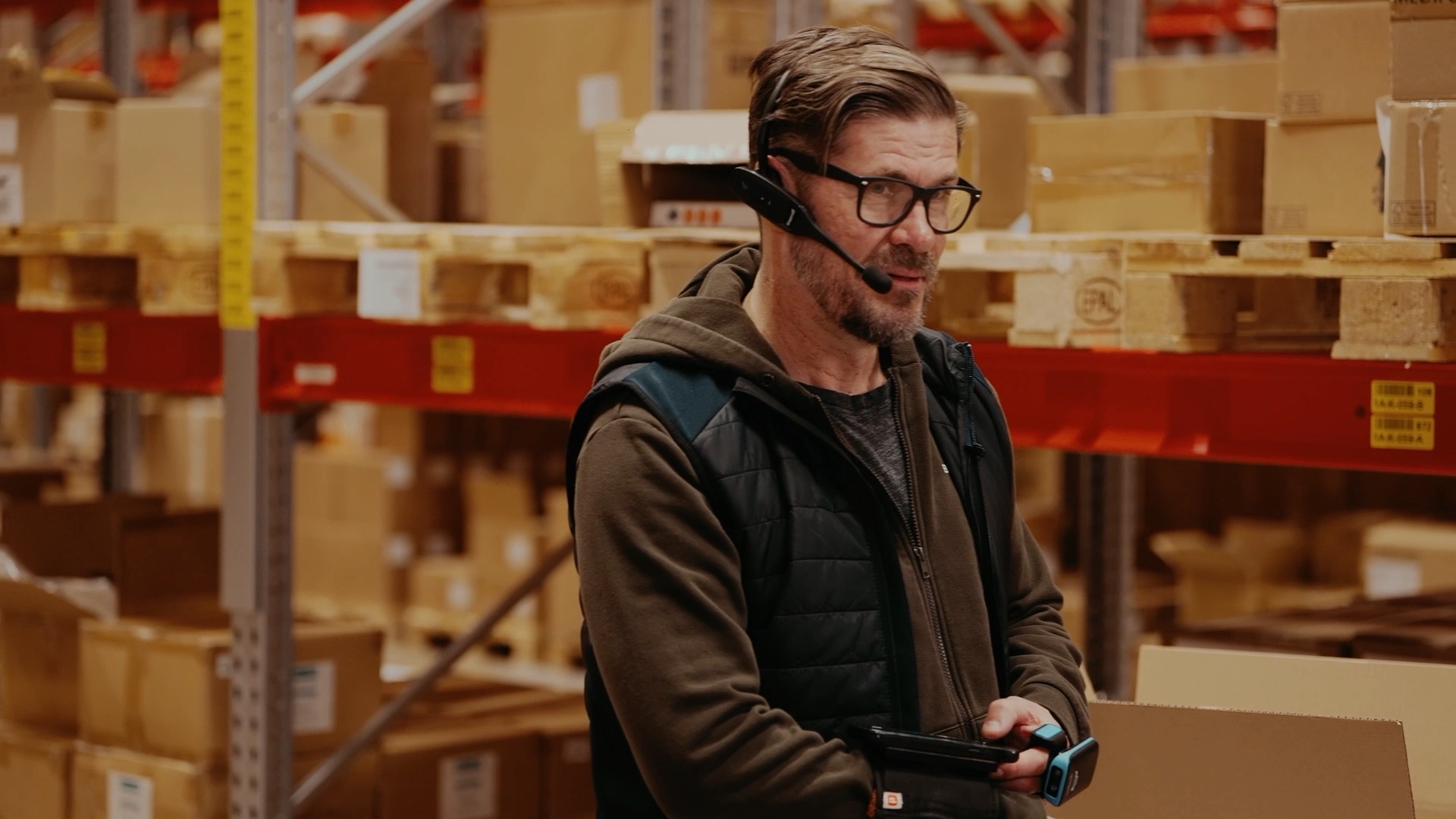 eCommerce warehouse worker using voice picking system for efficient order fulfilment.